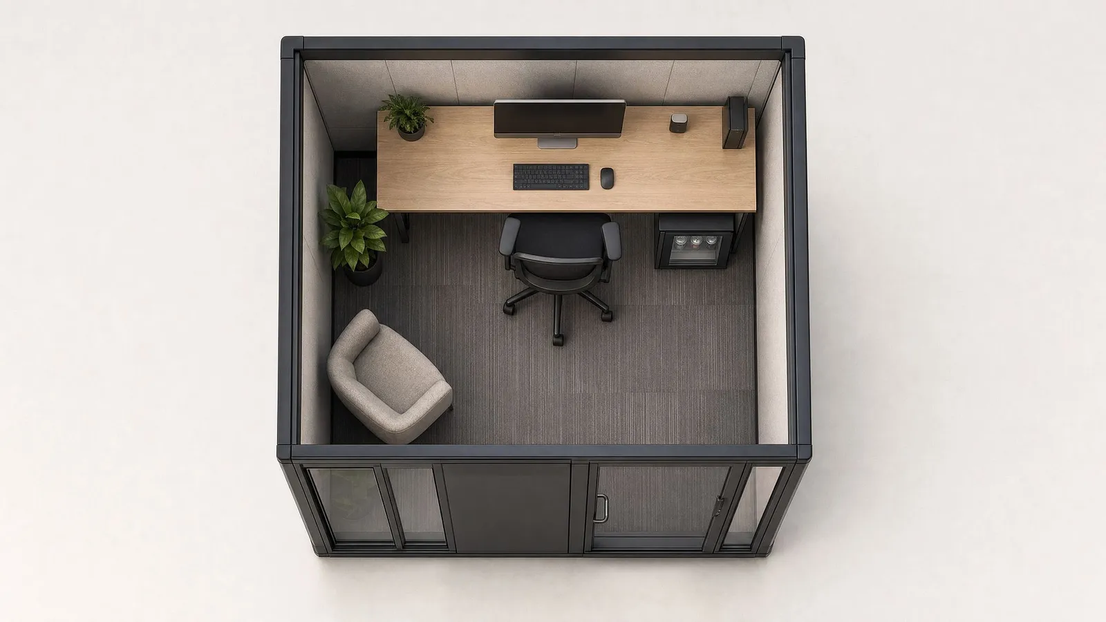 Top-down view into an 8 by 10 foot pod: desk and monitor, ergonomic chair, lounge seat and door